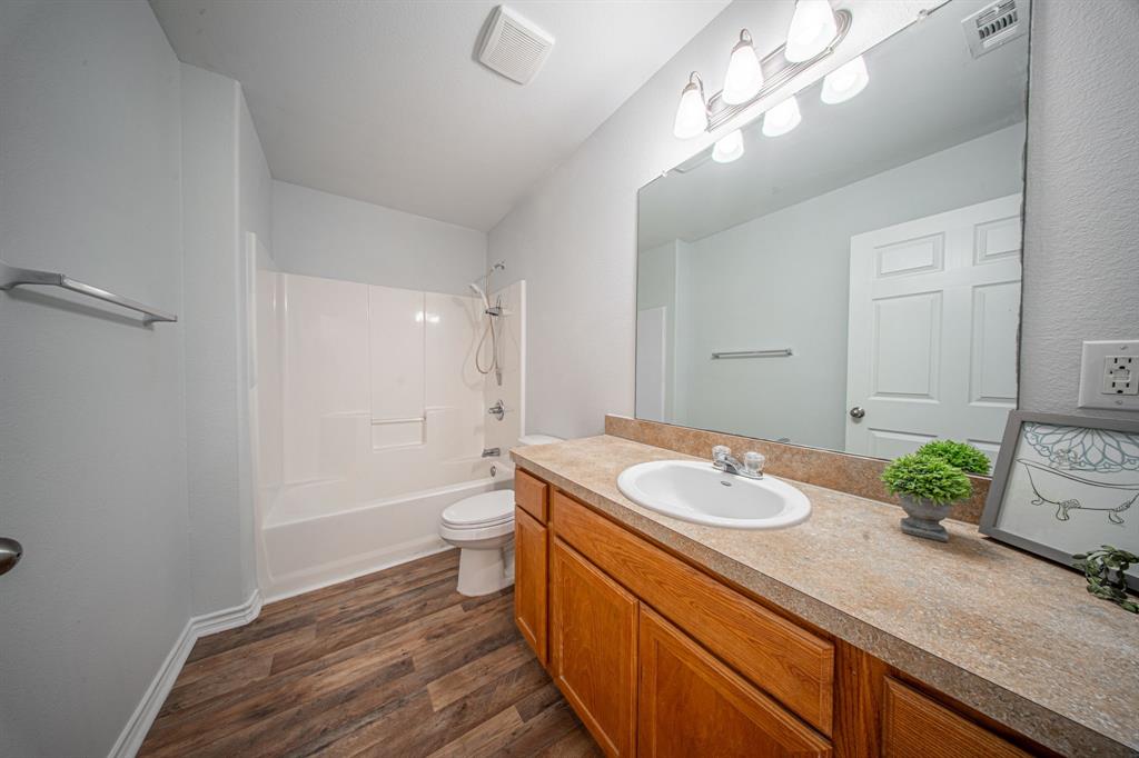 121 Washburn Road North Bells, TX 75414 - Photo 25 of 40 a bathroom with a granite countertop sink a toilet and shower