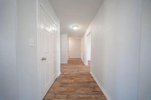 a view of a hallway with wooden floor