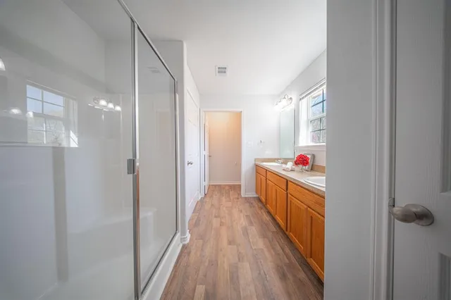 a view of a hallway with wooden floor and furniture