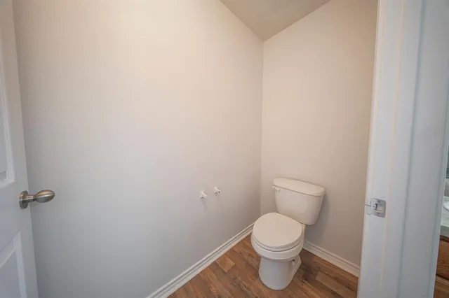 a white toilet sitting next to a white wall