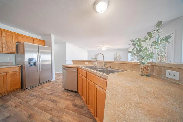 a kitchen with stainless steel appliances granite countertop a sink a stove and a refrigerator