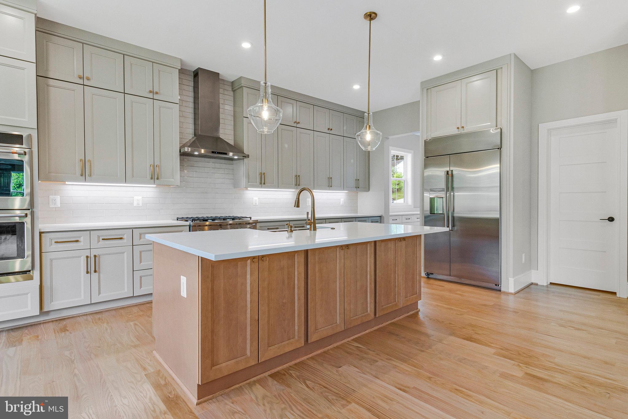 2300 Meridian Street Falls Church, VA 22046 - Photo 11 of 40 a kitchen with stainless steel appliances granite countertop a sink a stove a refrigerator and island with wooden floor