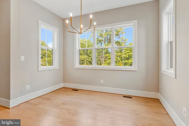 a kitchen with stainless steel appliances granite countertop a sink a stove a refrigerator and island with wooden floor