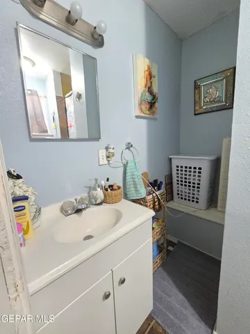 a bathroom with a sink a bed and a mirror