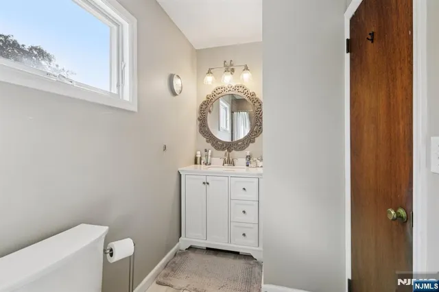 a bathroom with a granite countertop toilet sink and mirror