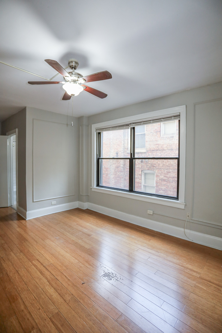5326 South Cornell Avenue, Unit 314 Chicago, IL 60615 - Photo 3 of 11 a view of an empty room with wooden floor and a window