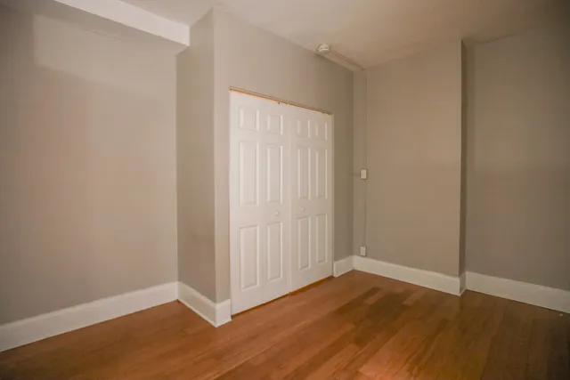 a view of an empty room with wooden floor