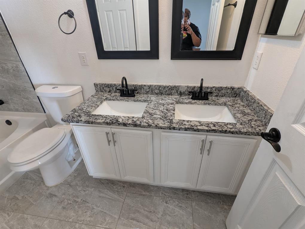1538 Algonkin Loop Orlando, FL 32828 - Photo 18 of 48 a bathroom with a granite countertop sink and a mirror