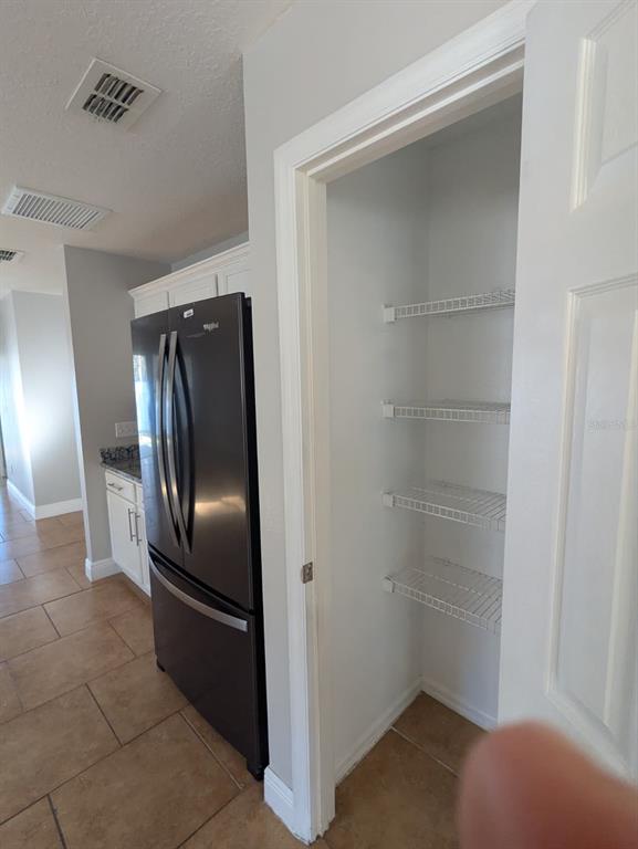 1538 Algonkin Loop Orlando, FL 32828 - Photo 28 of 48 a view of a refrigerator in kitchen and an empty room
