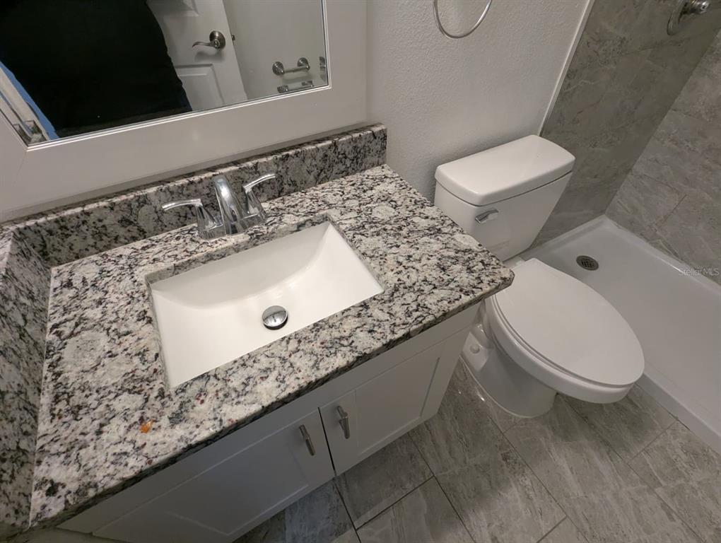 1538 Algonkin Loop Orlando, FL 32828 - Photo 29 of 48 a bathroom with a granite countertop toilet sink and mirror