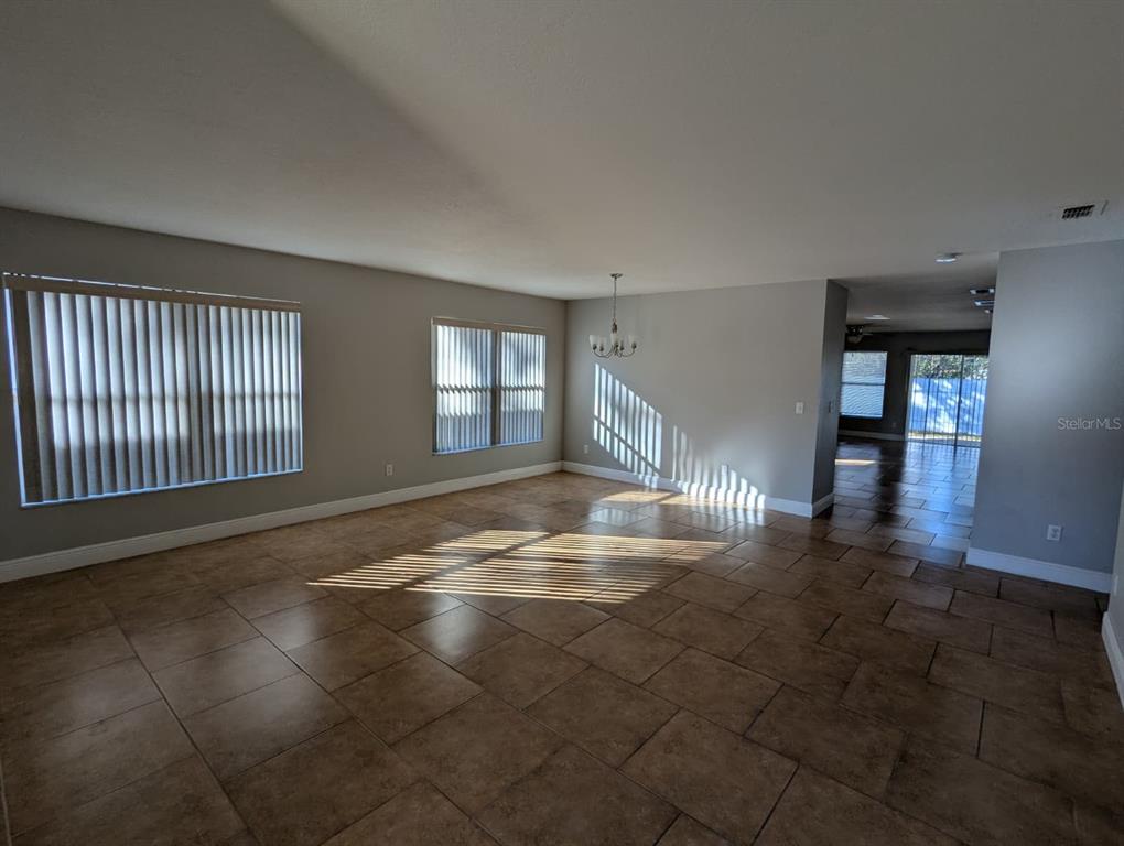 1538 Algonkin Loop Orlando, FL 32828 - Photo 44 of 48 an empty room with floor to ceiling windows and fireplace