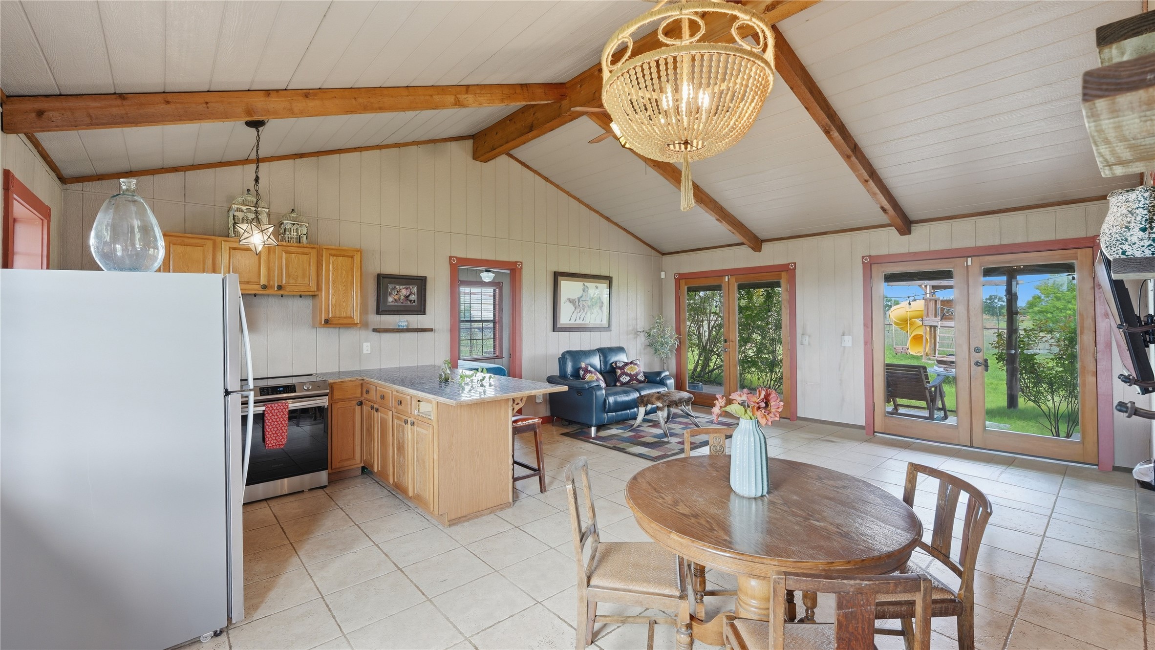 127 Offer Llano, TX 78643 - Photo 25 of 40 Vaulted ceiling with exposed wood beams, planked ceiling, and a beaded chandelier
