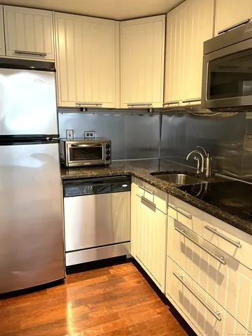a kitchen with granite countertop a sink a stove and cabinets