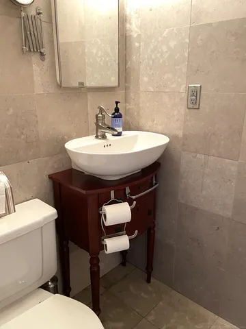 a bathroom with a sink toilet and a mirror