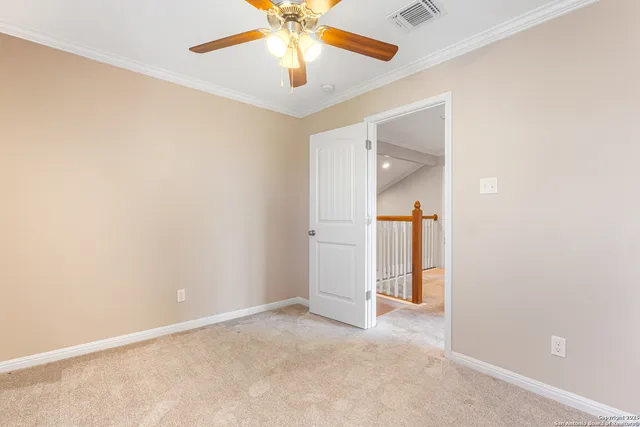 an empty room with closet and a chandelier fan