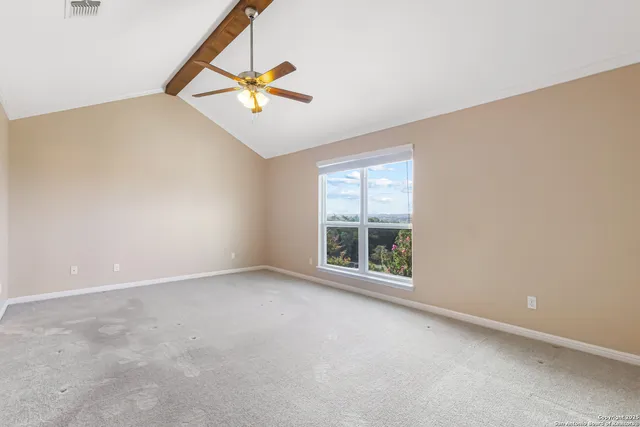 an empty room with windows and fan