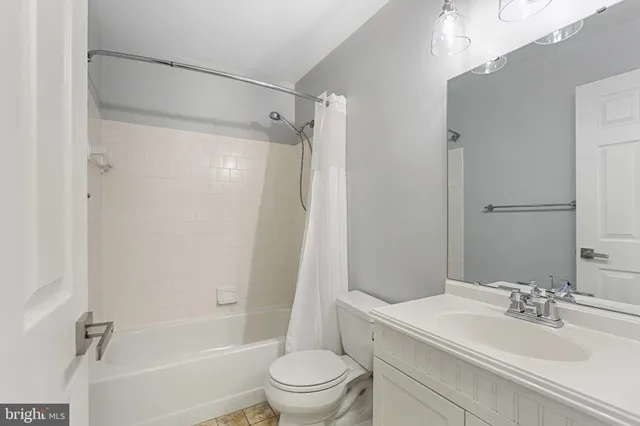 an empty room with a chandelier fan and windows