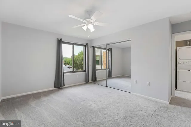 a view of an empty room with a chandelier fan
