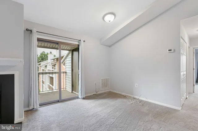 an empty room with large window and front door