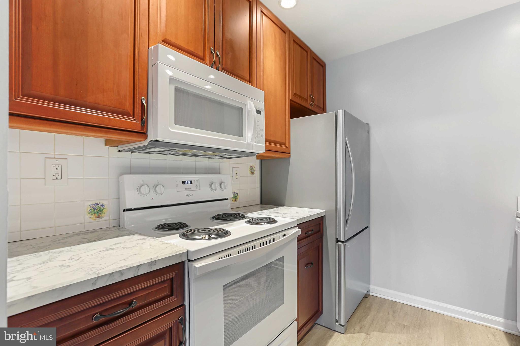 1110 Castle Harbor Way, Unit 3D Glen Burnie, MD 21060 - Photo 10 of 30 a kitchen with a stove and a microwave