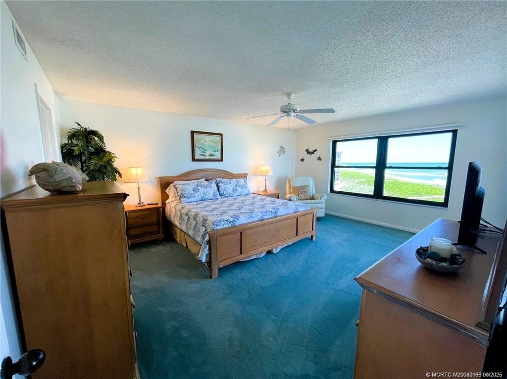 2491 Northeast Ocean Boulevard, Unit 302 Stuart, FL 34996 - Photo 15 of 35 a bedroom with a bed and large windows