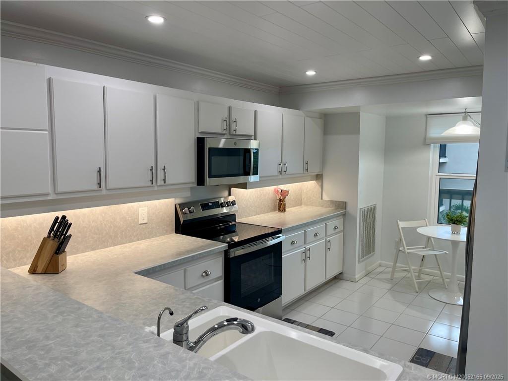 2491 Northeast Ocean Boulevard, Unit 302 Stuart, FL 34996 - Photo 4 of 35 a kitchen with a sink stove and microwave
