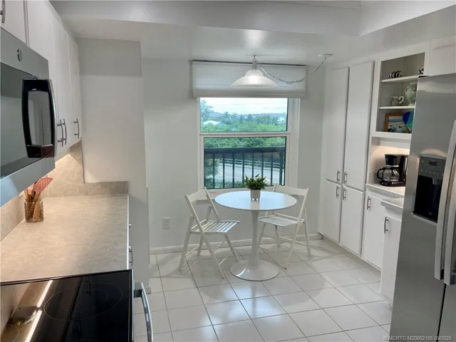 a kitchen with stainless steel appliances a table and chairs