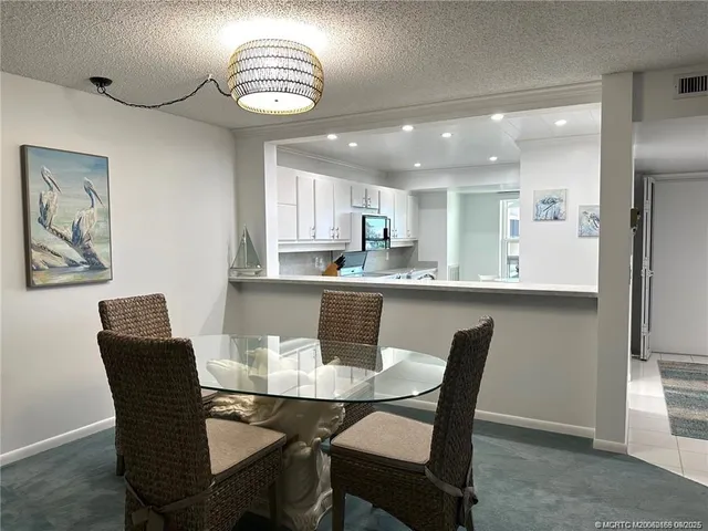 a view of a dining room and a kitchen with a dining table chairs