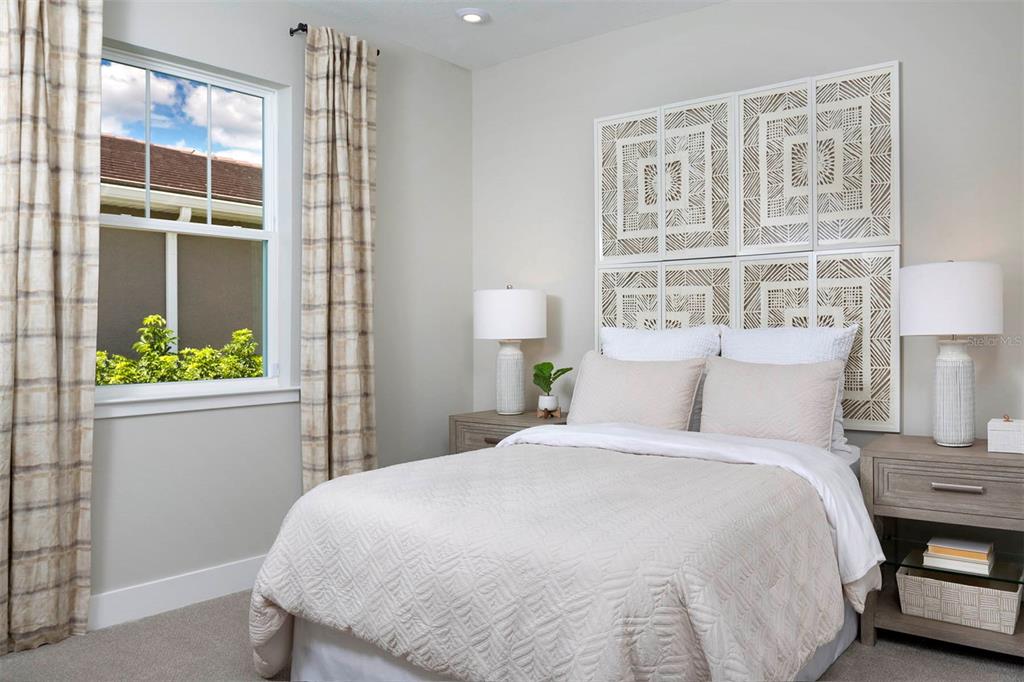 17787 Stillness Court Venice, FL 34293 - Photo 4 of 36 a large bed sitting in a bedroom next to a window and a lamp