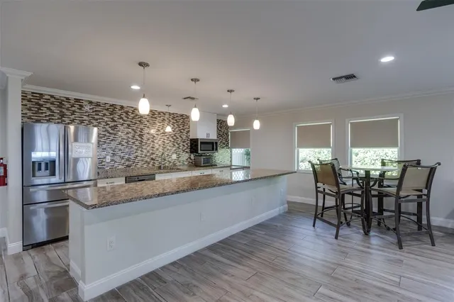 a view of a swimming pool with a bench and palm trees