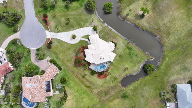 an aerial view of a house with a yard and lake view