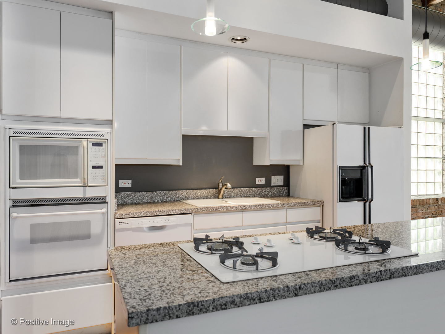 11 North Green Street, Unit 3CD Chicago, IL 60607 - Photo 10 of 40 a kitchen with kitchen island granite countertop a sink stove and white cabinets