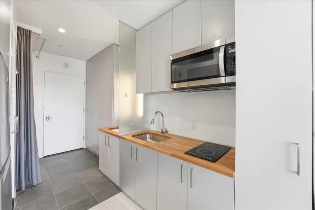 a kitchen with stainless steel appliances granite countertop a sink and a microwave