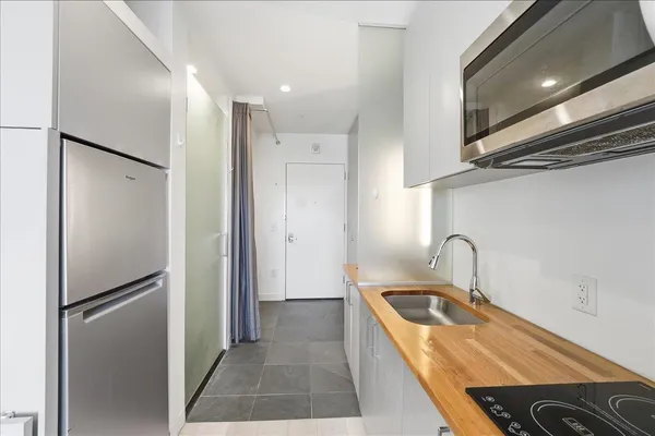 a kitchen with stainless steel appliances granite countertop a refrigerator and a sink