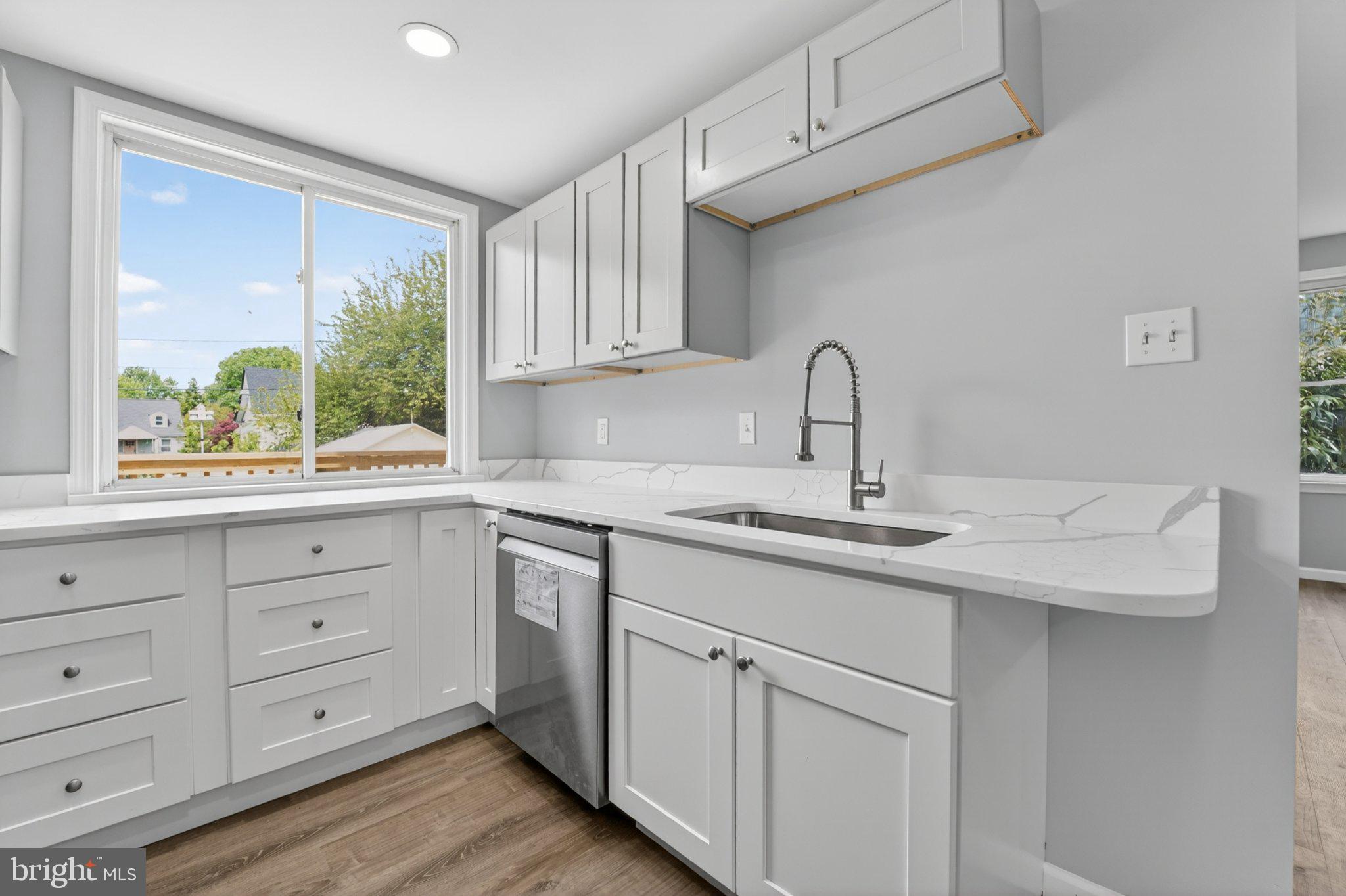 5312 Catalpha Road Baltimore, MD 21214 - Photo 19 of 59 a kitchen with white cabinets and a window
