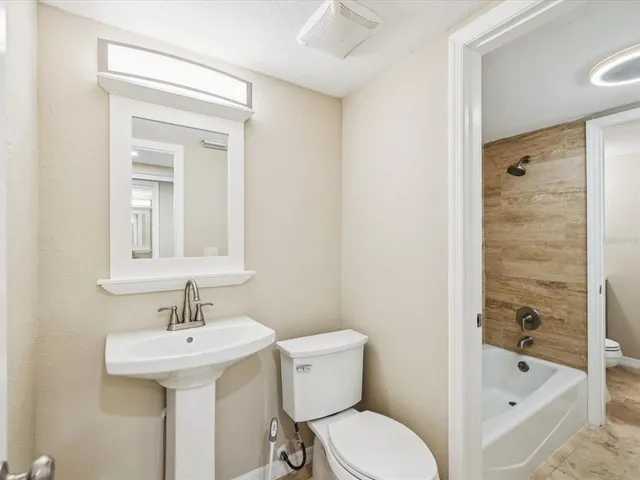 a bathroom with a tub shower vanity and a sink