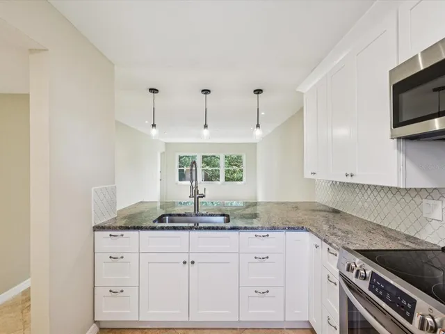 a kitchen with a granite countertop window and refrigerator