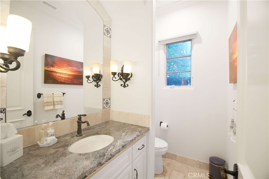 1015 Gardena Road Encinitas, CA 92024 - Photo 12 of 42 a bathroom with a granite countertop sink toilet and mirror