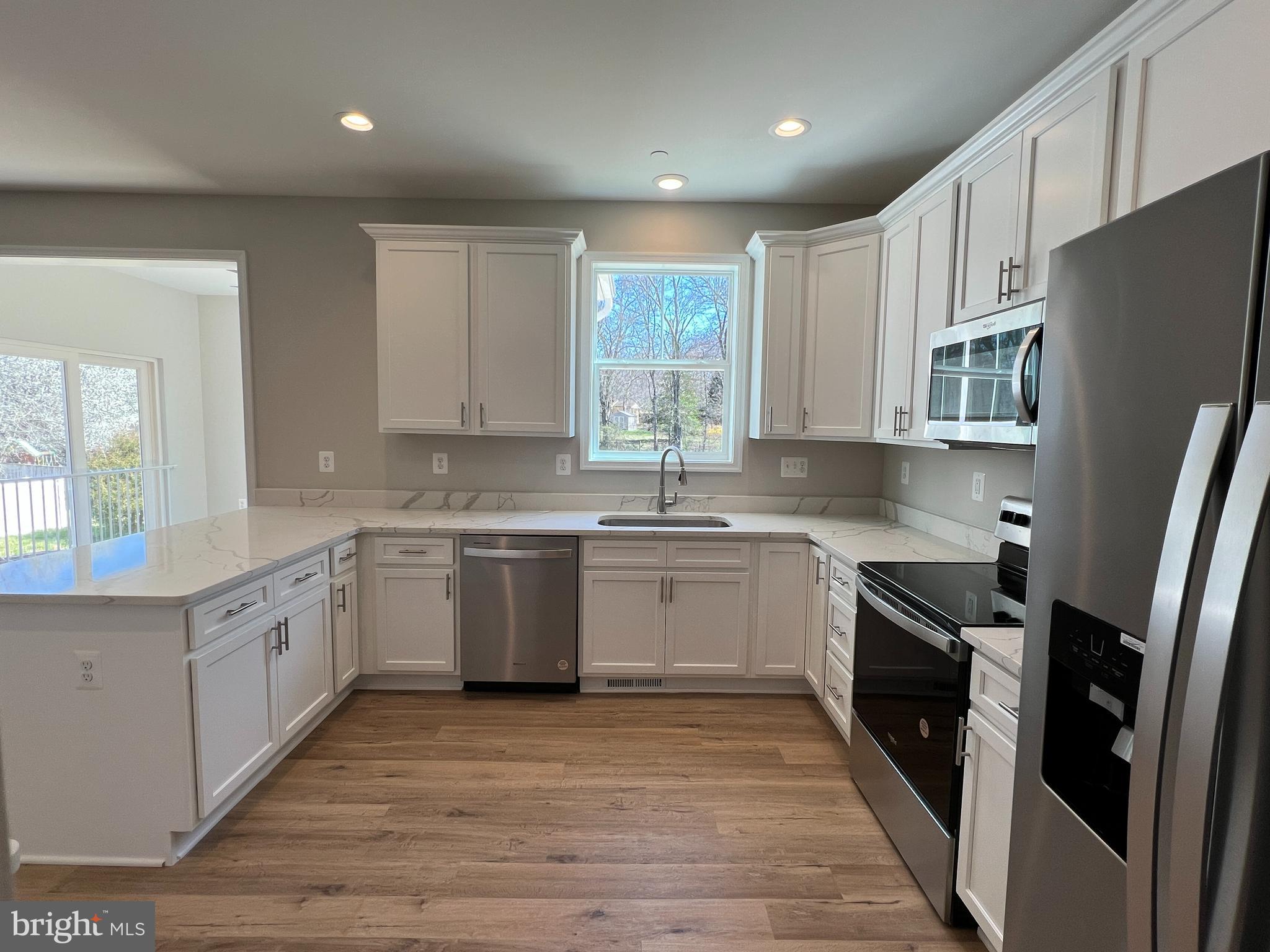 5 Cissell Avenue Laurel, MD 20723 - Photo 12 of 21 a kitchen with a sink wooden floor and stainless steel appliances