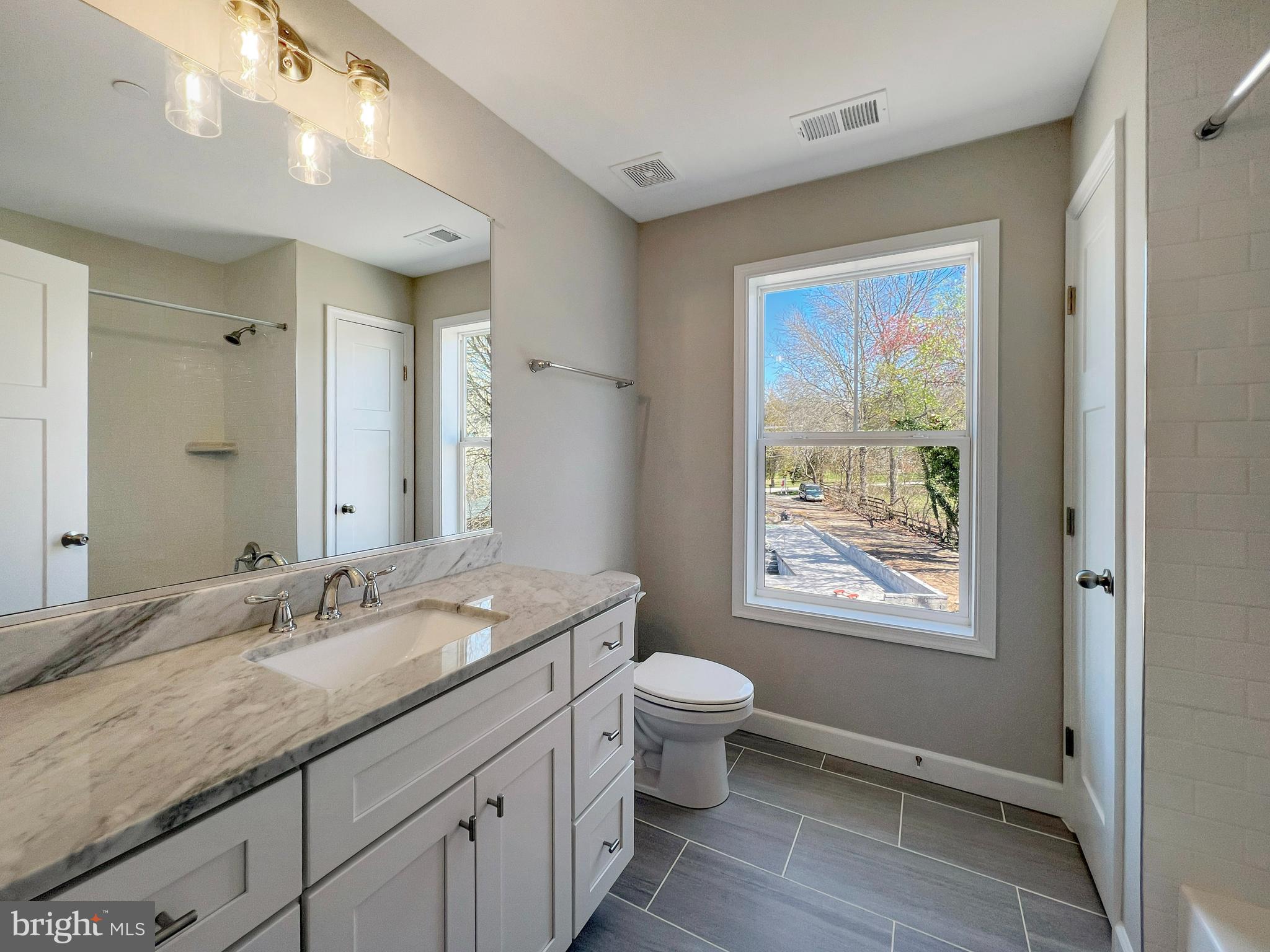 5 Cissell Avenue Laurel, MD 20723 - Photo 13 of 21 a bathroom with a granite countertop sink a toilet a large mirror and a window