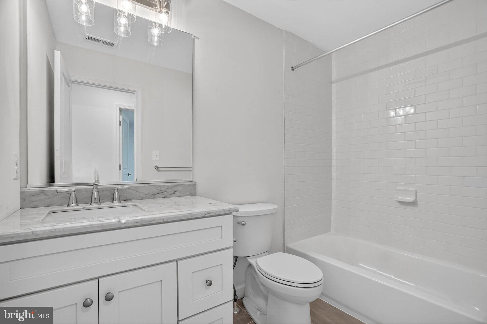 5 Cissell Avenue Laurel, MD 20723 - Photo 10 of 21 a bathroom with a granite countertop sink a toilet and a bathtub