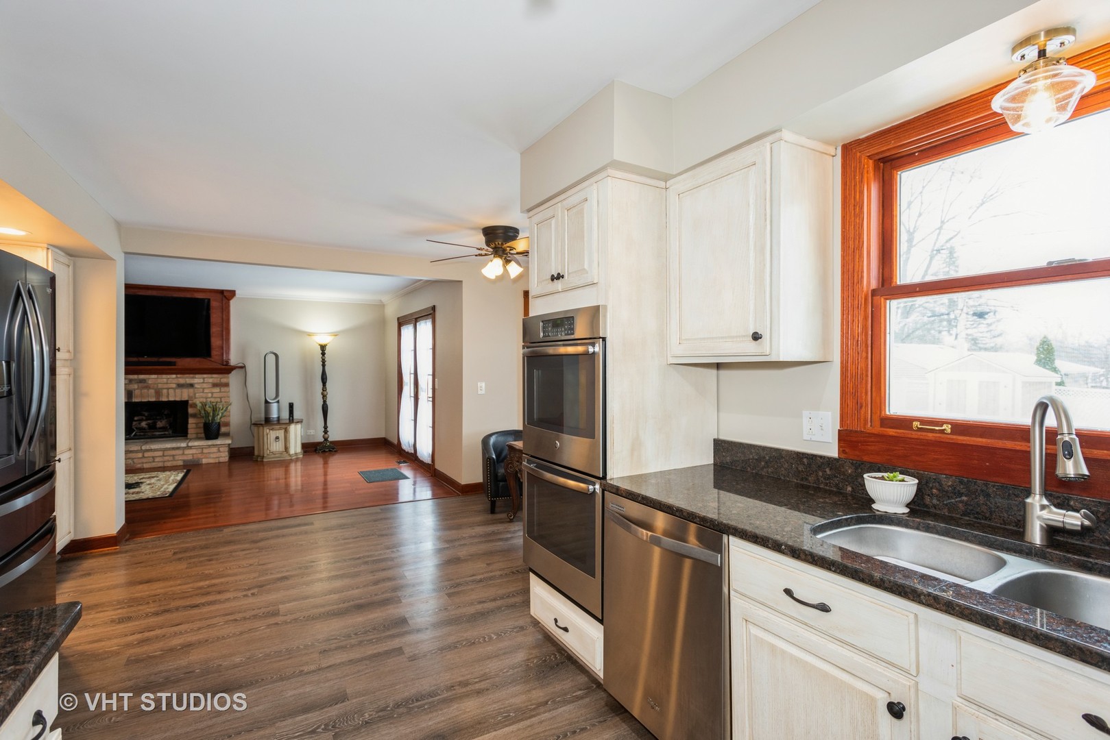 S543 Robbins Street Winfield, IL 60190 - Photo 6 of 17 a kitchen with granite countertop a stove a sink a refrigerator and white cabinets with wooden floor