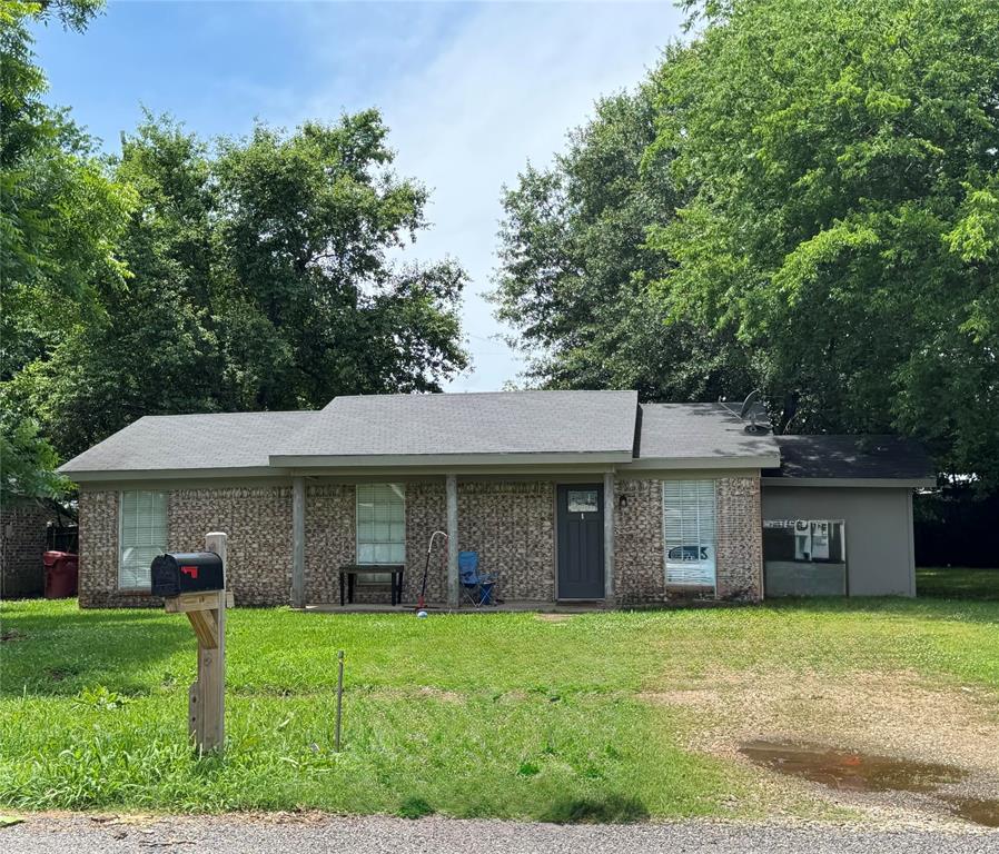 4515 Southeast Loop 286 Paris, TX 75460 - Photo 6 of 37 a front view of a house with a yard and trees