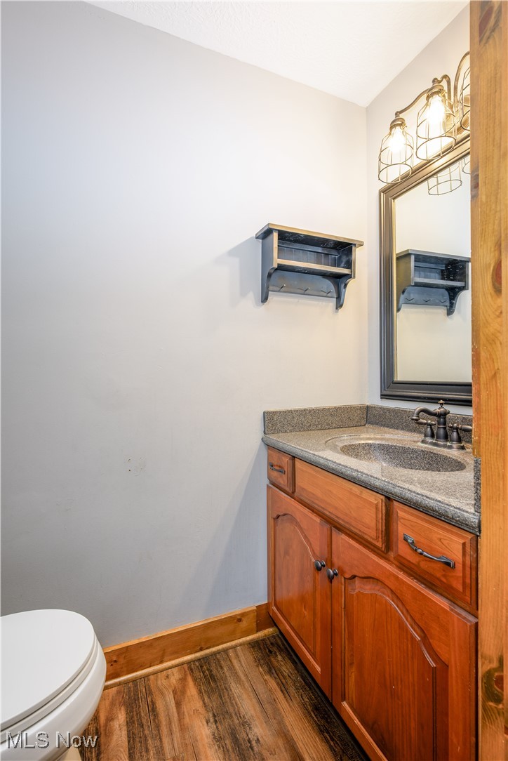 2061 Portage Line Road Mogadore, OH 44260 - Photo 24 of 48 Half bath featuring vanity, toilet, wood finished floors, and baseboards