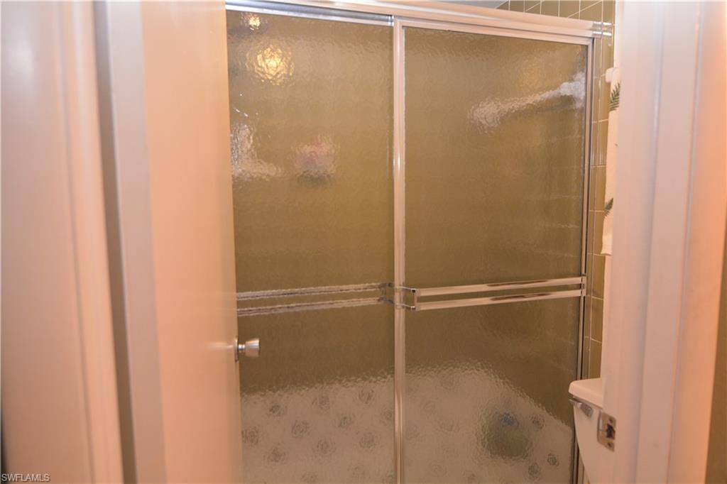 300 Valley Stream Drive, Unit A7 Naples, FL 34113 - Photo 13 of 23 a bathroom with a glass shower door