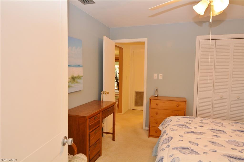 300 Valley Stream Drive, Unit A7 Naples, FL 34113 - Photo 17 of 23 a bedroom with a bed and wooden floor