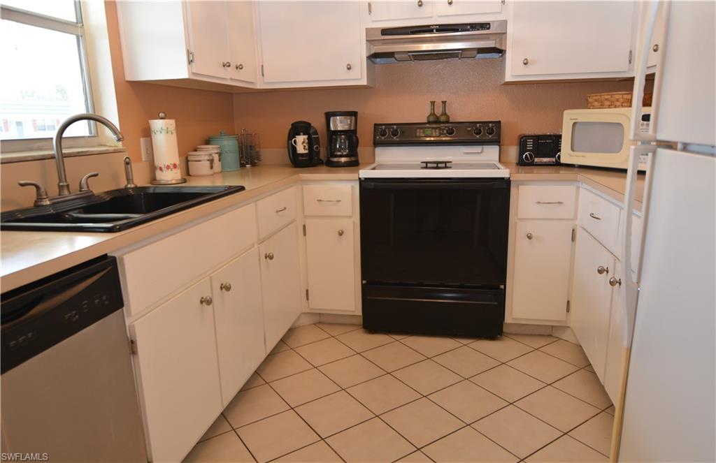 300 Valley Stream Drive, Unit A7 Naples, FL 34113 - Photo 3 of 23 a kitchen with stainless steel appliances a stove and a refrigerator