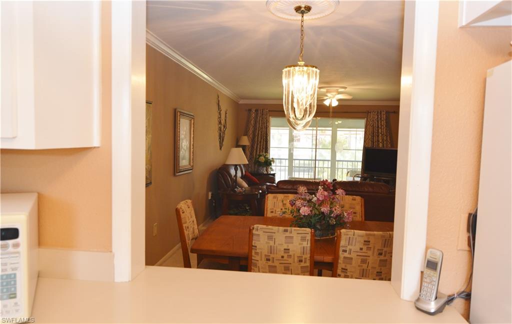 300 Valley Stream Drive, Unit A7 Naples, FL 34113 - Photo 4 of 23 a living room with fireplace furniture and a chandelier