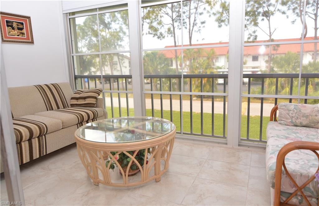 300 Valley Stream Drive, Unit A7 Naples, FL 34113 - Photo 7 of 23 a living room with furniture and a floor to ceiling window