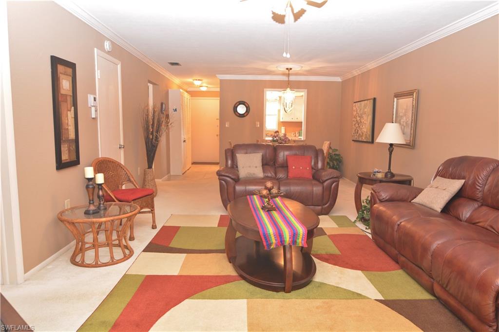 300 Valley Stream Drive, Unit A7 Naples, FL 34113 - Photo 9 of 23 a living room with furniture and a lamp